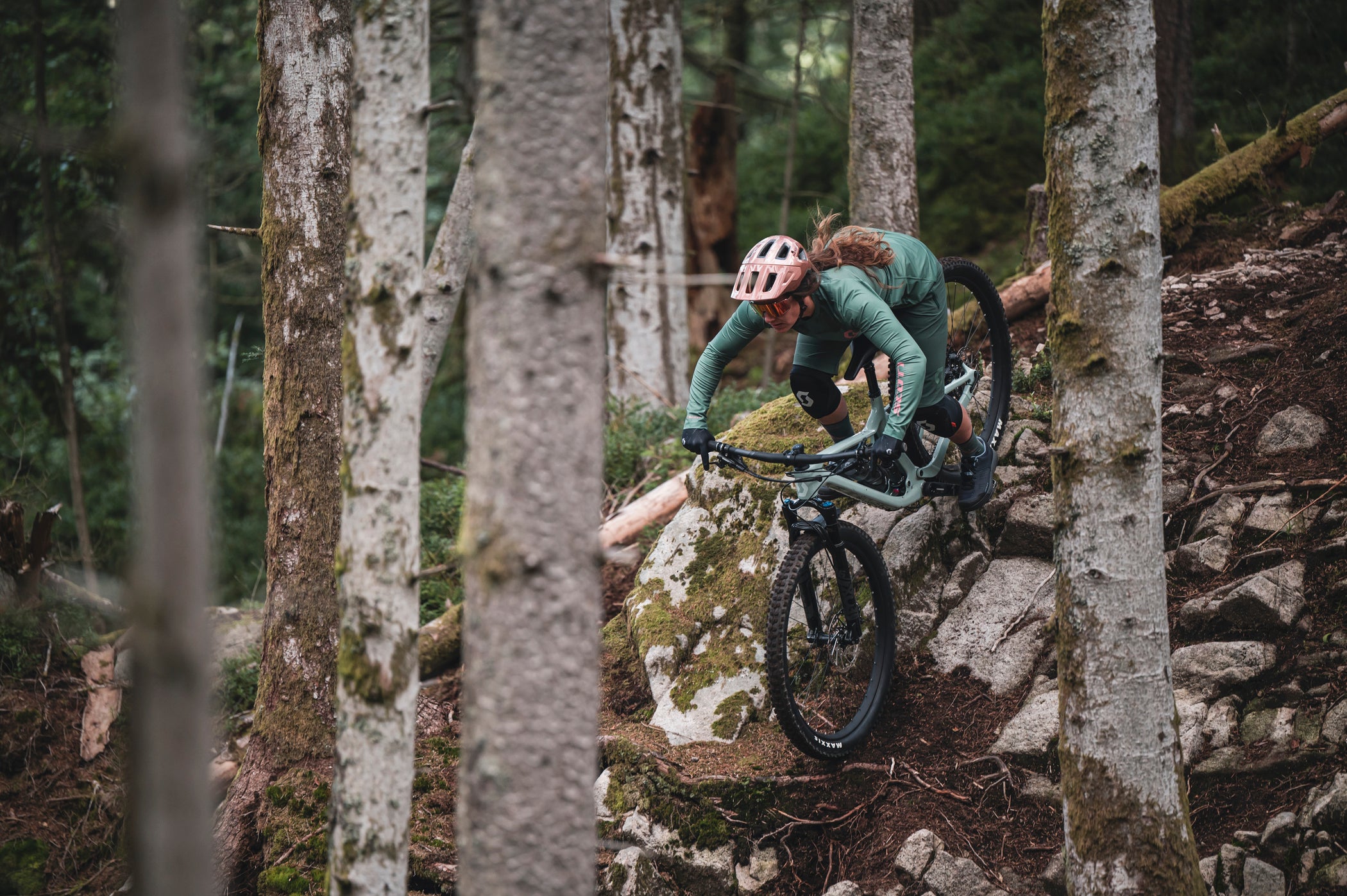 Riding a scott contessa mountain bike down a rock roll between some trees