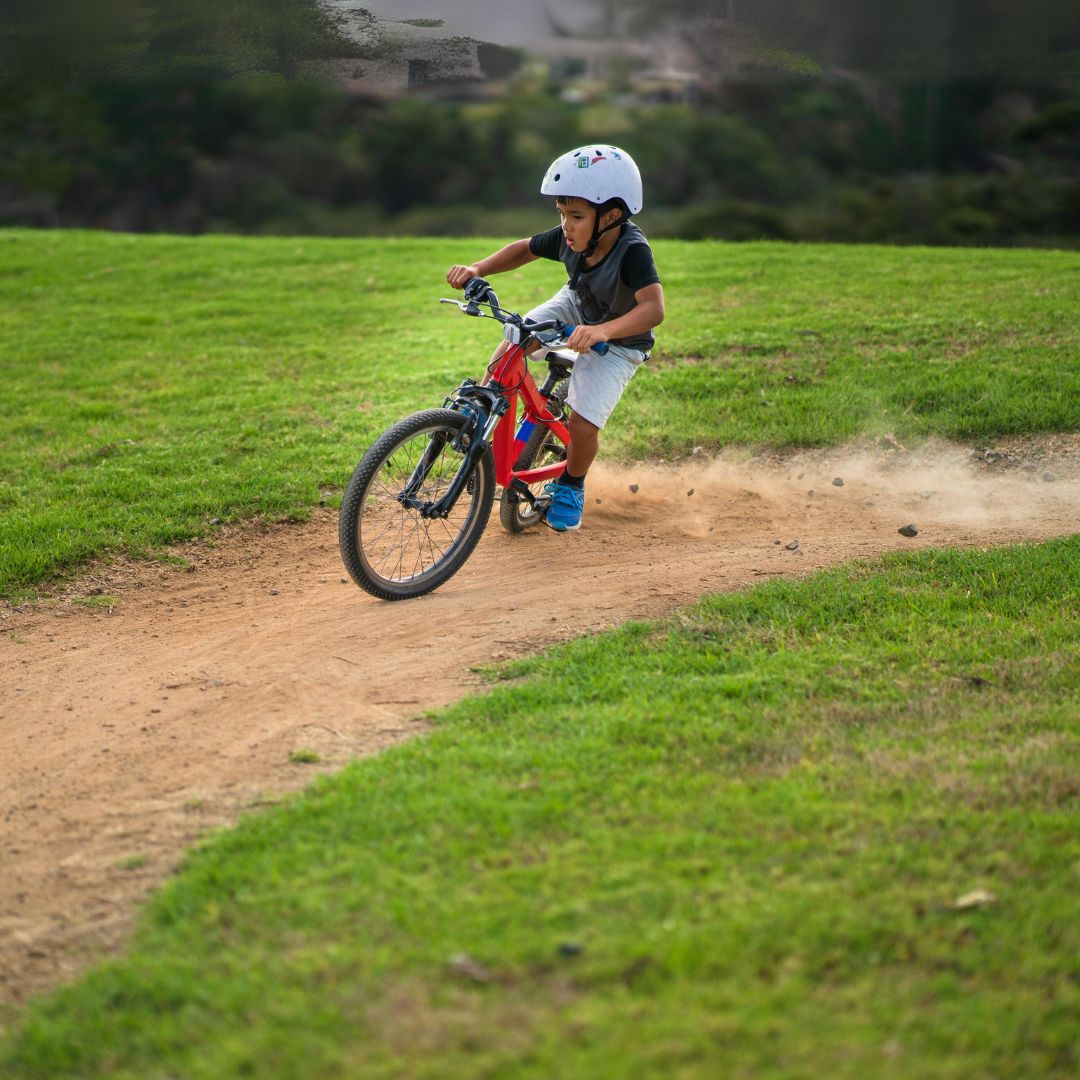 A kid ripping a corner on a mountain bike